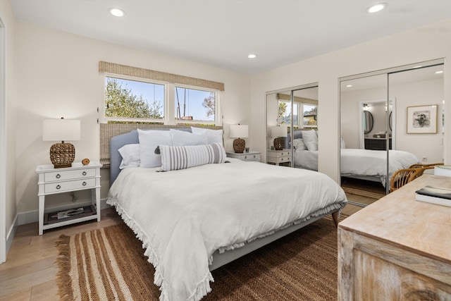 bedroom featuring multiple closets and hardwood / wood-style floors