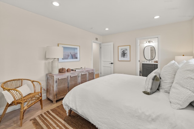 bedroom featuring wood-type flooring and ensuite bath