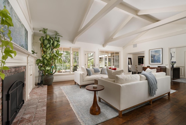 living room with dark hardwood / wood-style floors, beamed ceiling, and a brick fireplace