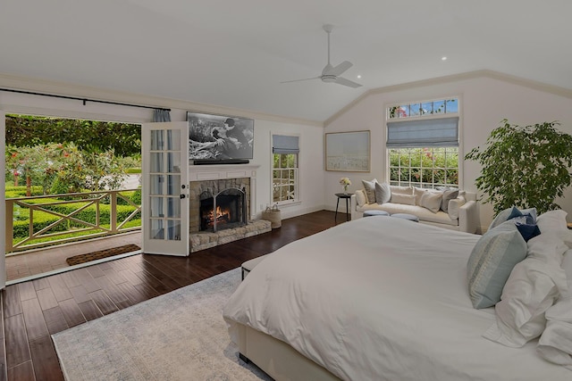 bedroom with ceiling fan, dark wood-type flooring, a fireplace, and lofted ceiling