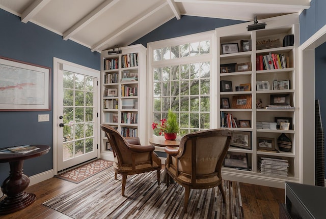 living area with hardwood / wood-style flooring and vaulted ceiling with beams