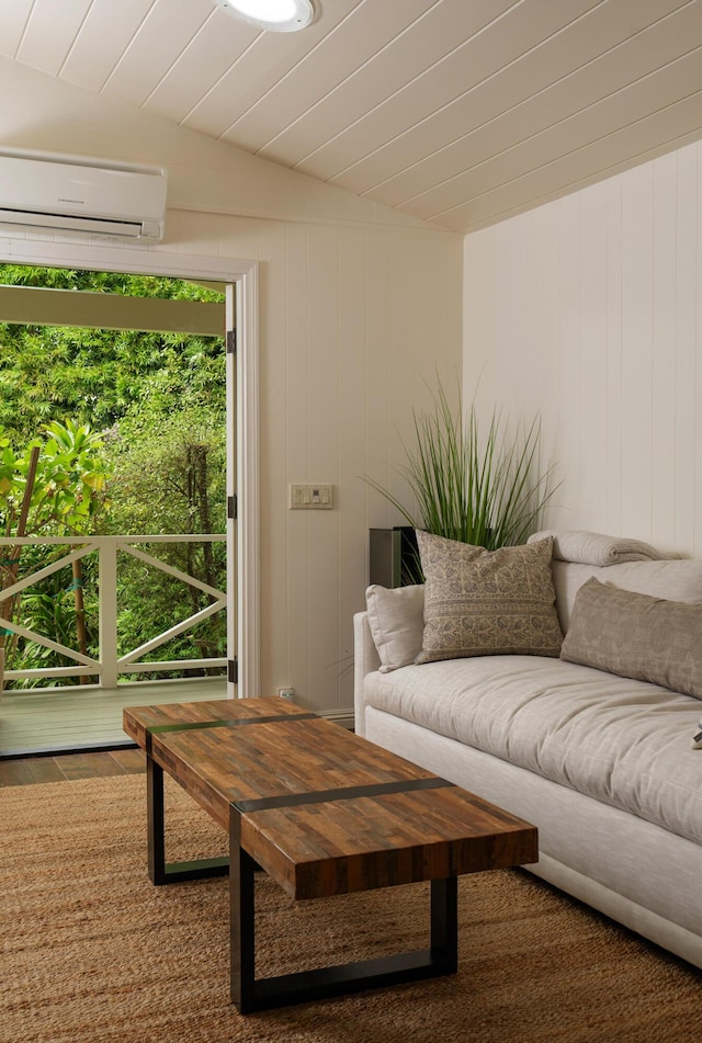 living room with wood walls, a wall unit AC, and vaulted ceiling