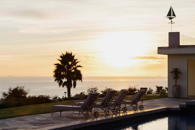 pool at dusk with a patio area