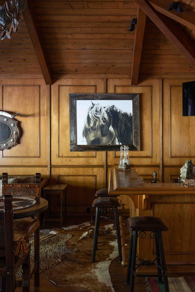 interior space with vaulted ceiling with beams, wooden walls, and wooden ceiling