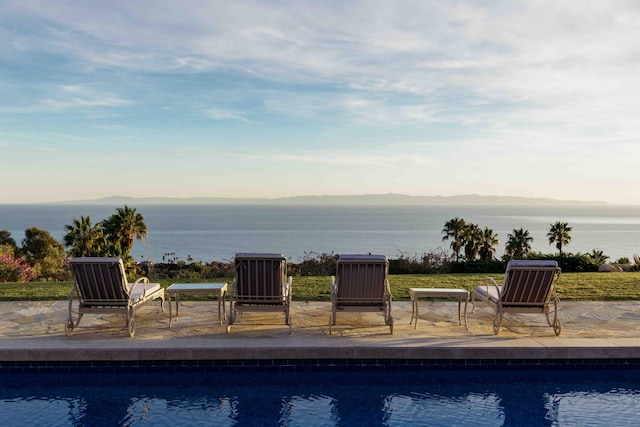 view of pool with a patio and a water and mountain view