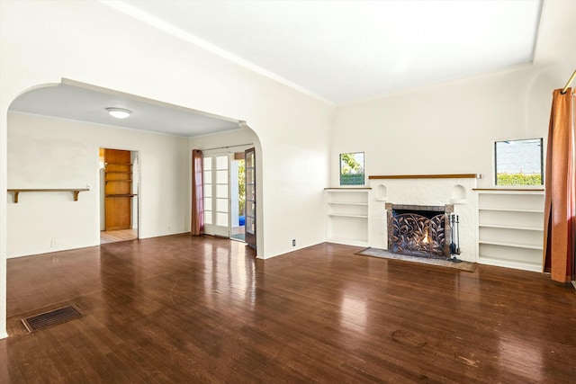 unfurnished living room with hardwood / wood-style flooring and built in shelves