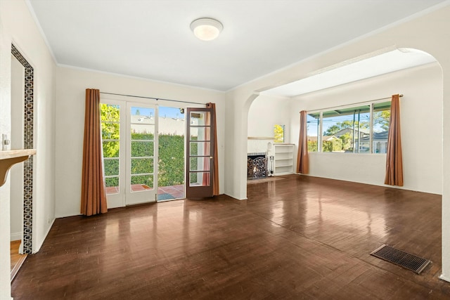 unfurnished living room with dark hardwood / wood-style flooring and ornamental molding