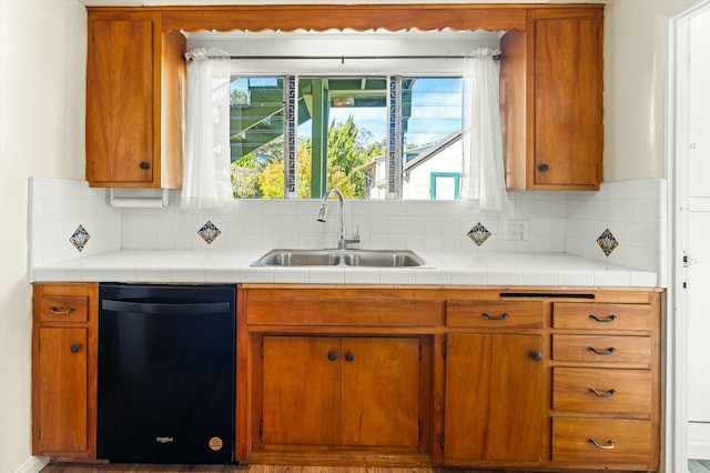 kitchen with sink, backsplash, tile countertops, and black dishwasher