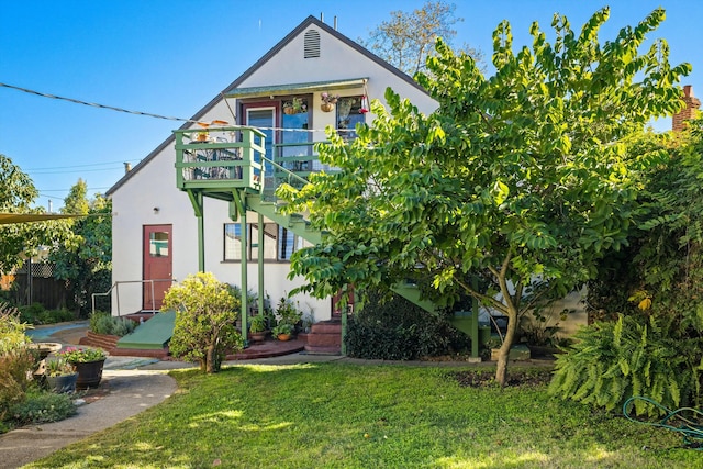 view of front of home featuring a balcony and a front yard