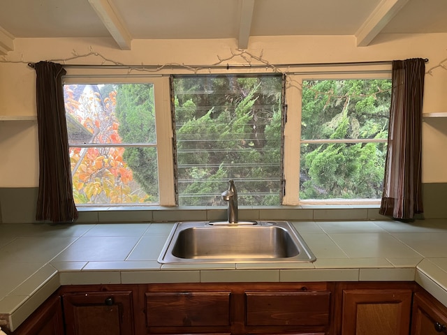 kitchen featuring sink, a wealth of natural light, and beam ceiling