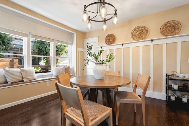 dining area with dark wood-type flooring and an inviting chandelier