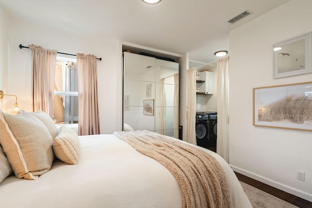 bedroom featuring wood-type flooring, washer and dryer, and a closet