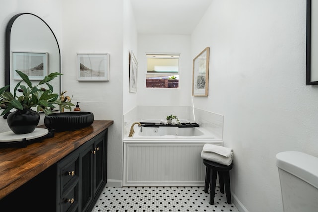 315 E Micheltorena St, Santa Barbara, CA 93101 - bathroom featuring a tub with jets, tile patterned floors, baseboards, vanity, and toilet
