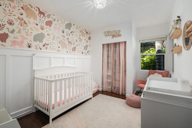 315 E Micheltorena St, Santa Barbara, CA 93101 - bedroom with a crib, wainscoting, and wood finished floors