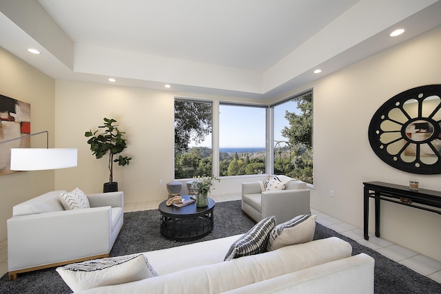 tiled living room featuring a raised ceiling