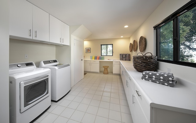 laundry room featuring cabinets, separate washer and dryer, and light tile patterned floors