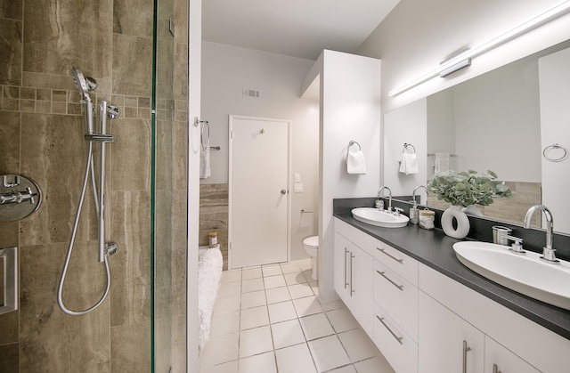 bathroom featuring tiled shower, tile patterned floors, toilet, and vanity