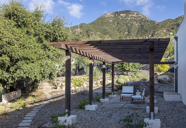 view of patio / terrace with a pergola and a mountain view