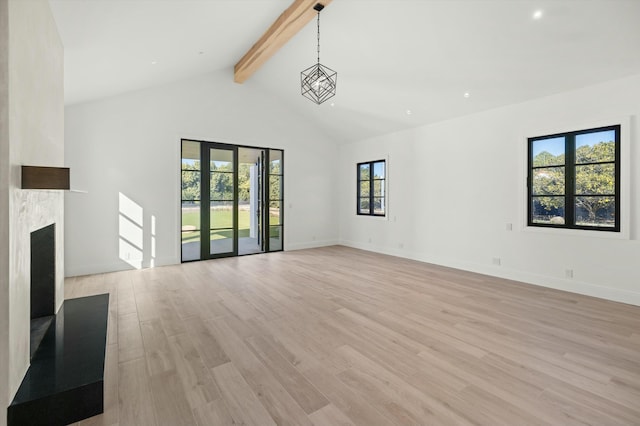 unfurnished living room featuring high vaulted ceiling, beam ceiling, and light wood-type flooring