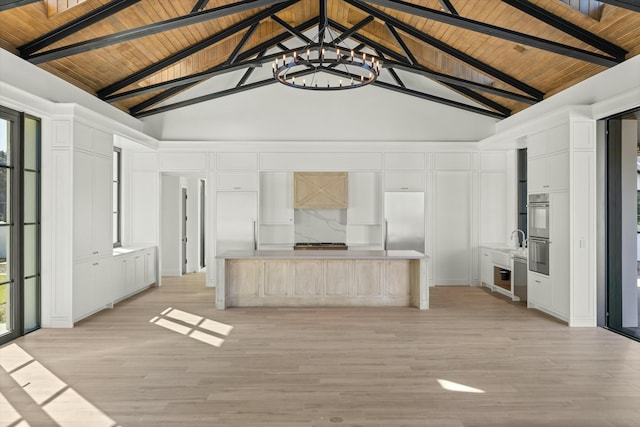 unfurnished living room featuring light hardwood / wood-style flooring, beamed ceiling, and high vaulted ceiling