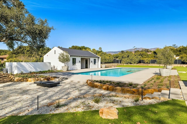 view of pool featuring an outbuilding, a mountain view, a patio, and an outdoor fire pit