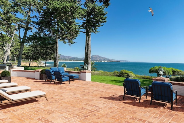 view of patio / terrace with an outdoor hangout area and a water and mountain view