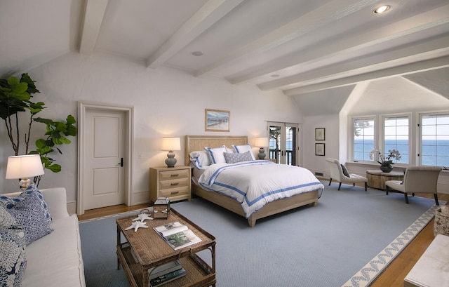 bedroom featuring vaulted ceiling with beams, hardwood / wood-style flooring, and a water view