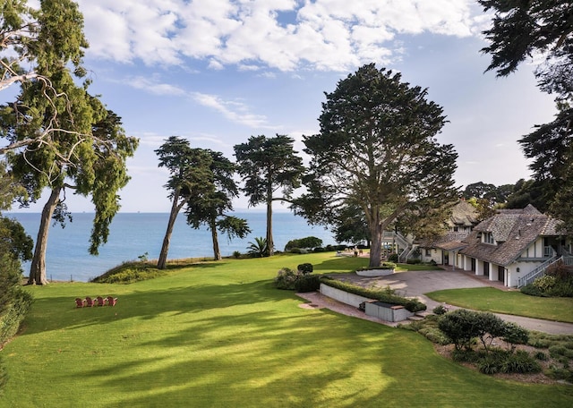 view of community with a lawn and a water view