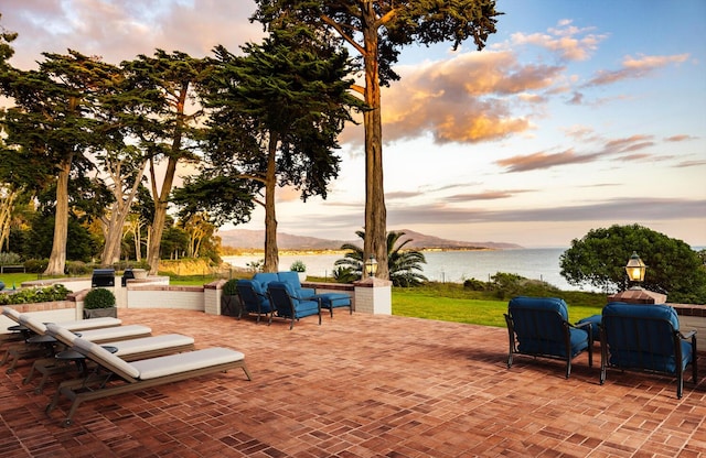 patio terrace at dusk with a water and mountain view