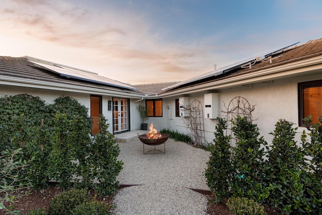 back of property featuring a patio area, a fire pit, and stucco siding