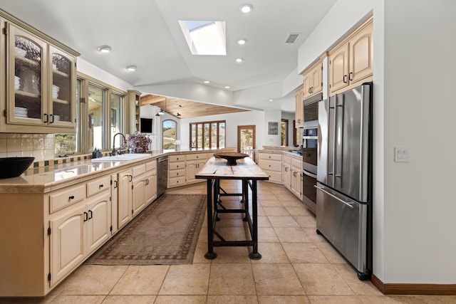 kitchen featuring a sink, visible vents, light countertops, freestanding refrigerator, and glass insert cabinets