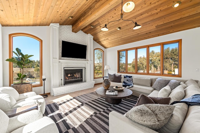 living room featuring vaulted ceiling with beams, plenty of natural light, a fireplace, and wood ceiling