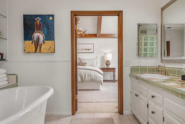 ensuite bathroom with a freestanding bath, connected bathroom, vanity, and tile patterned floors