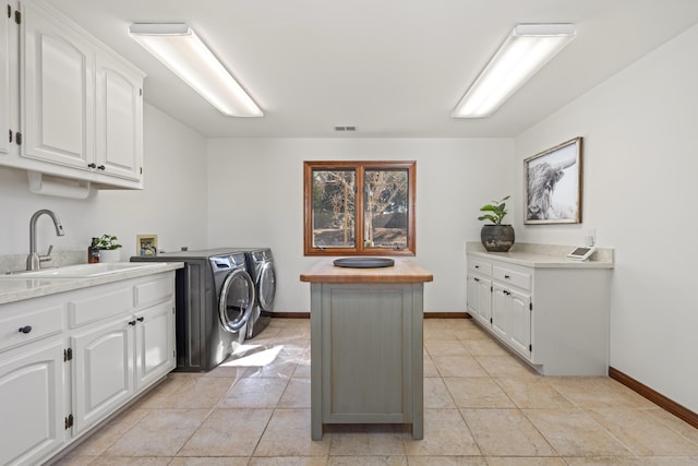 laundry room featuring cabinet space, visible vents, a sink, independent washer and dryer, and baseboards