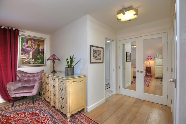 living area with light hardwood / wood-style floors and french doors