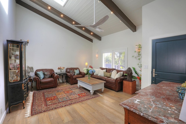 living room featuring a skylight, a high ceiling, light hardwood / wood-style floors, wooden ceiling, and beamed ceiling