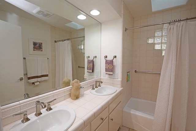 bathroom featuring vanity, backsplash, and shower / bath combination with curtain