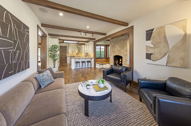 living room with a fireplace, wood-type flooring, and beam ceiling