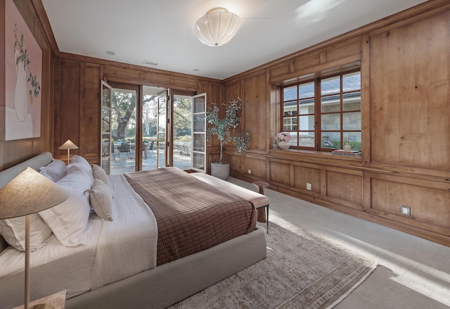 carpeted bedroom featuring access to outside and wood walls