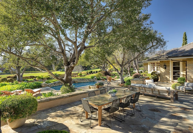 view of patio with an outdoor living space and an outbuilding