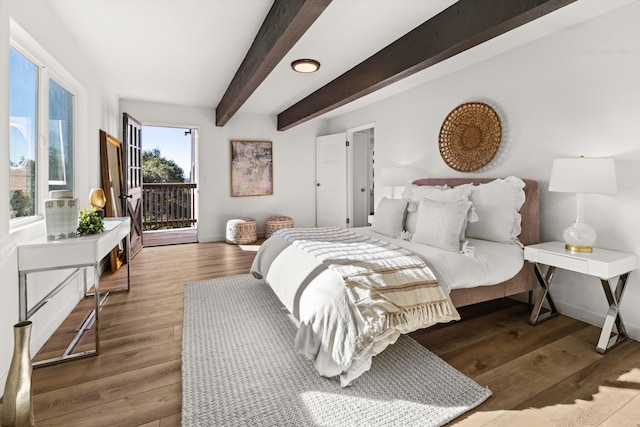 bedroom with beamed ceiling, dark wood-type flooring, and access to outside