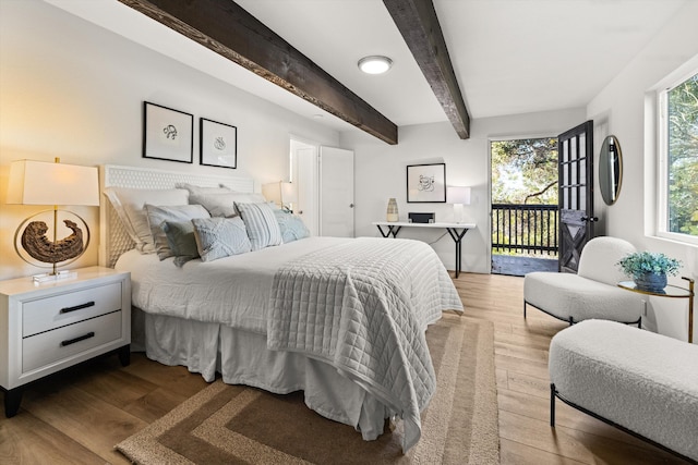 bedroom featuring beam ceiling, access to exterior, and light wood-type flooring