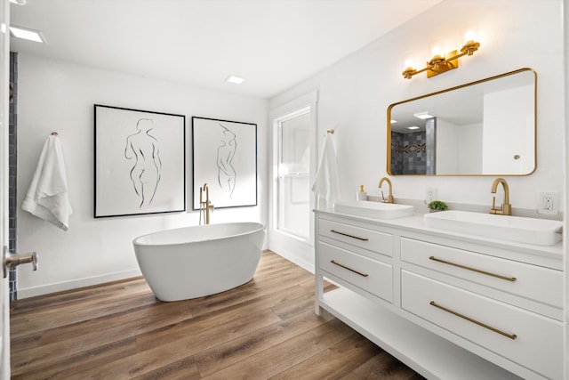 bathroom with vanity, hardwood / wood-style floors, and plus walk in shower