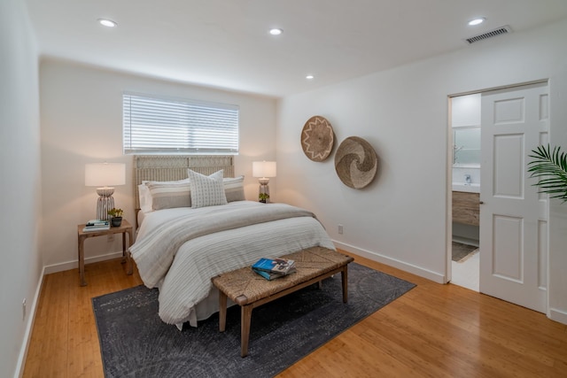 bedroom featuring light hardwood / wood-style floors and ensuite bathroom