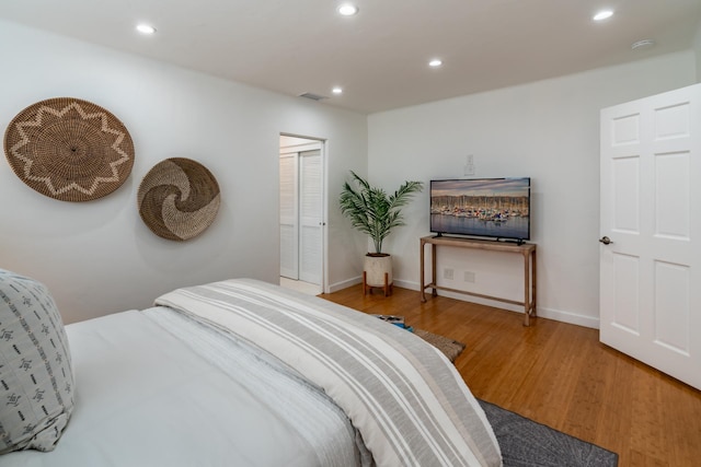 bedroom with wood-type flooring and a closet