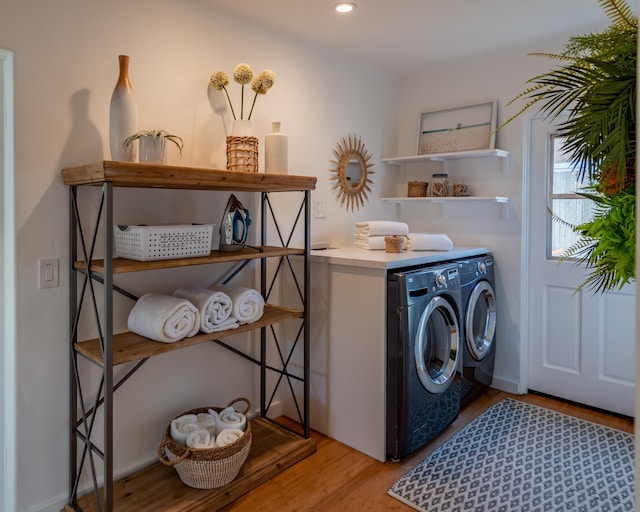 laundry room with light hardwood / wood-style flooring and washing machine and dryer