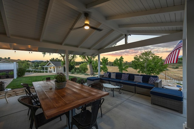 patio terrace at dusk featuring a gazebo, outdoor lounge area, an outbuilding, and ceiling fan