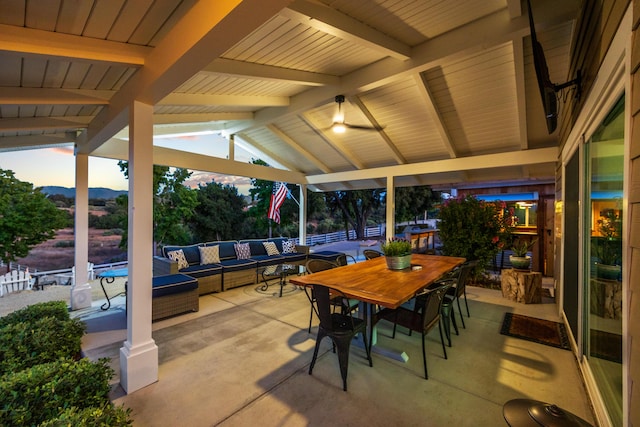 patio terrace at dusk featuring ceiling fan and an outdoor hangout area