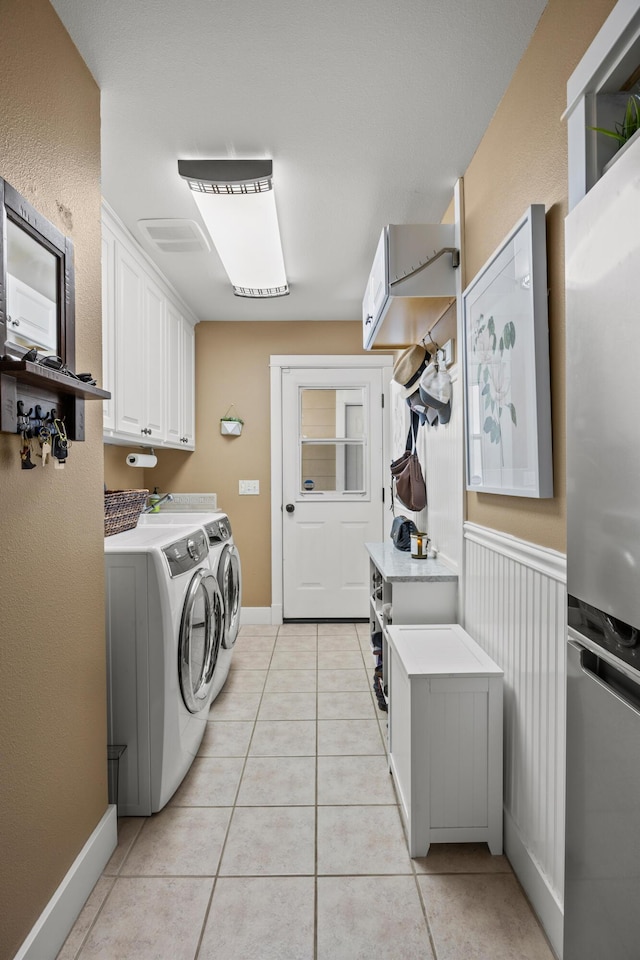 laundry room featuring cabinets, separate washer and dryer, and light tile patterned floors