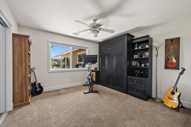 exercise room with ceiling fan and carpet floors